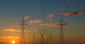 Stromleitung bei Sonnenuntergang – Strompreiskompensation Österreich