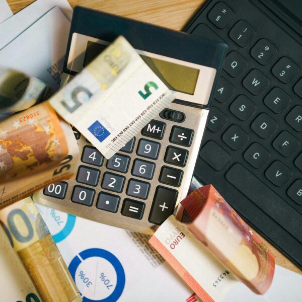 Euro-Banknoten, Rechner und Laptop als Symbol für Lohntransparenz und Gehaltsplanung in Österreich
