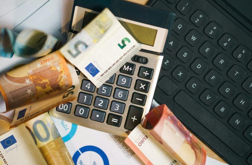 Euro-Banknoten, Laptop und Haushaltsbudget als Symbol für finanzielle Belastung trotz Arbeit