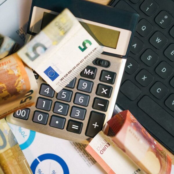 Euro-Geldscheine, Taschenrechner und Laptop als Symbol für Klimabonus-Phishing in Österreich